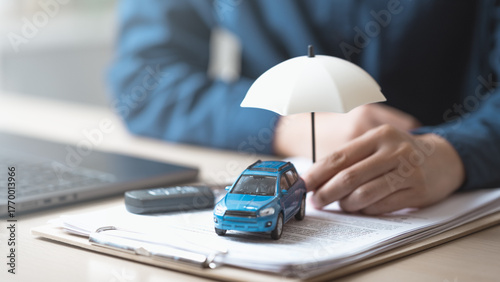 Foto insurance, car, policy, coverage, claim, A miniature car with an umbrella on insurance documents symbolizes car insurance policy, financial protection, and risk coverage for vehicles and drivers
