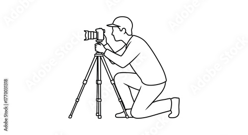 A person wearing a cap kneels down to take a photo with a camera mounted on a tripod silhouette