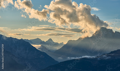 Dramatic landscape with sharp jagged peaks of Cadini di Misurina piercing through clouds and mist, Tre Cime di Lavaredo in Dolomites. Gorgeous rock pillars at sunset. Discovery the beauty of earth.