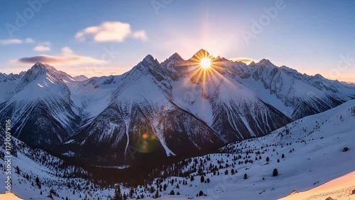 Majestic snow-capped mountain range lit by a radiant sunrise, with trees below