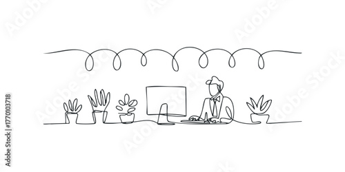 Man at desk with computer and potted plants