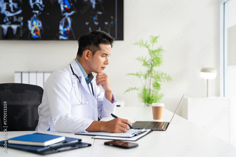 Fototapeta premium Concentrated physician working on computer looking at laptop screen thinking on problem solution concept. Serious doctor wearing white coat doing online research at workplace.