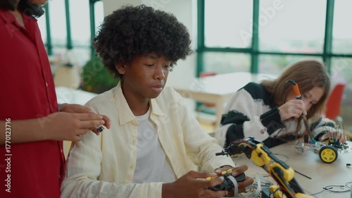 Group of high school students building and programming electric toys and robots project at classroom. Innovative technology development