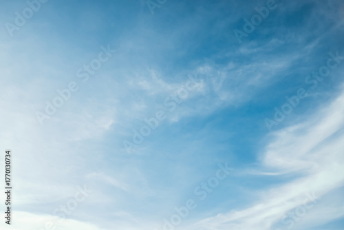 the sky is clear blue with fluffy white clouds, the sky is very bright, and the sun shines.