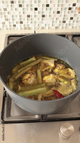 Peeled and sliced artichokes are pot cooked at home. Healthy eating and traditional Italian cuisine. Seasonal farm produce.