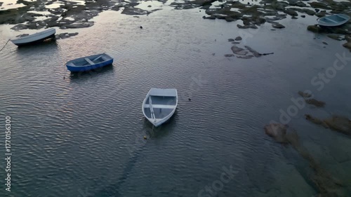 Low-altitude aerial view of boats at low tide on the seaside, breathtaking summer sunset landscape.