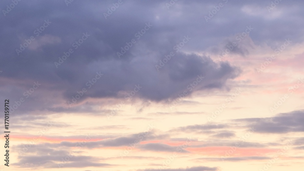 Obraz premium The sky at dawn or sunset with clouds in pink and purple tones is a natural scene where the soft light of the sun penetrates dark and light clouds.