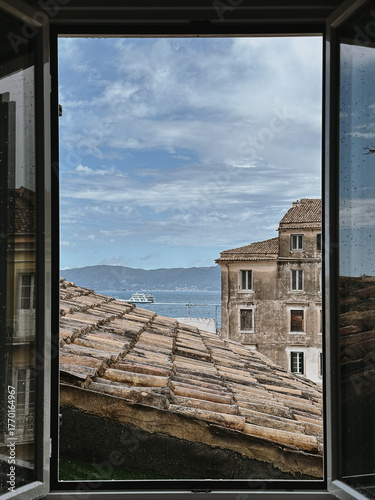 View of Rooftops and Sea from Window