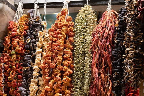 Colorful strings of dried peppers and vegetables hang in an Istanbul market