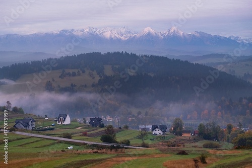 Beautiful scenery of snow-covered Tatras Mountains and village Sromowce Wyzne in autumn scenery in evening light, Poland