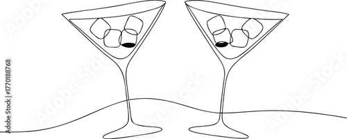 Two martini glasses with ice cubes and olives cocktail