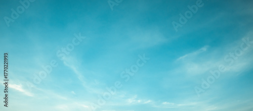 the sky is clear blue with fluffy white clouds, the sky is very bright, and the sun shines.