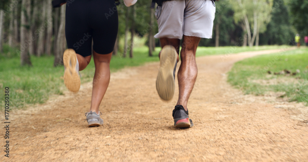 Fototapeta premium Fitness, legs and couple running outdoor for health, wellness or training with back. Man, woman and shoes of trail runner in woods for cardio workout, endurance exercise or practice in nature
