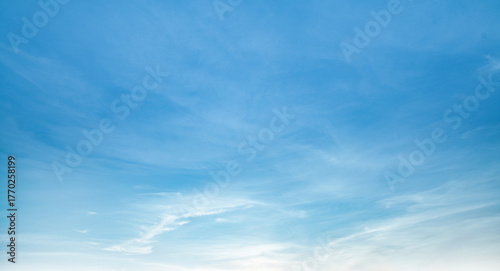 the sky is clear blue with fluffy white clouds, the sky is very bright, and the sun shines.