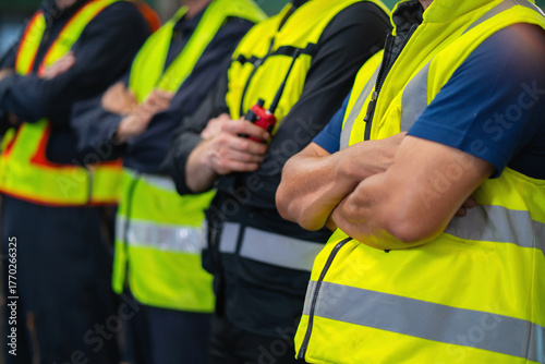 group of men in yellow safety vests stand together