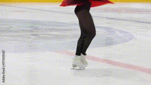 A figure skater does a spin on the ice. Close-up of legs, winter sports