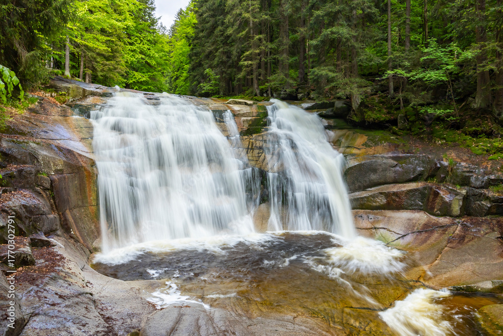 Naklejka premium Mumlava waterfall cascading over rocks in Harrachov, Czechia
