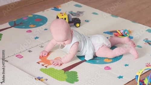 An adorable baby is crawling cheerfully on a vibrant and colorful playmat, exploring joyfully