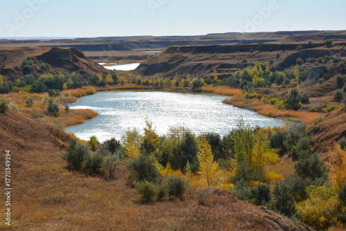 Autumn landscape with lake in canyon and yellow trees on shore