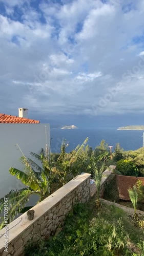 Scenic coastal view with sea, islands, banana trees, under cloudy sky, typical Mediterranean setting