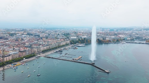 Aerial view of the iconic Jet d'Eau de Genève shooting a powerful stream of water high into the sky, a captivating contrast against the blue waters, Geneva, Switzerland.