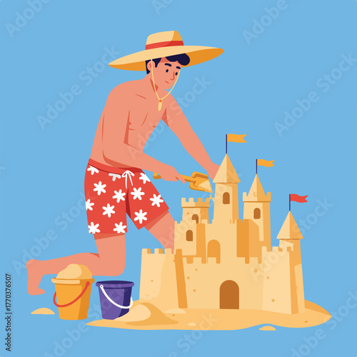 A shirtless person in beach shorts constructs a sandcastle with a bucket and shovel under a big straw hat