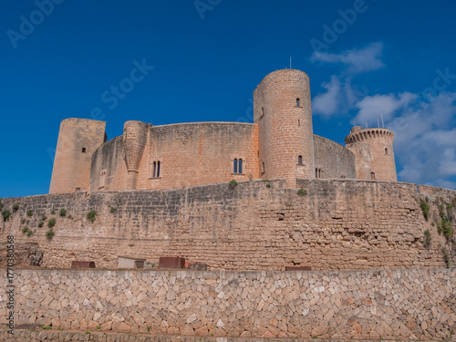 Castell de Bellver, Palma Mallorca, historic castle with multiple round towers stands majestically on a stone wall, clear blue sky, Majorca