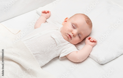 a four-month-old baby sleeping in a bed