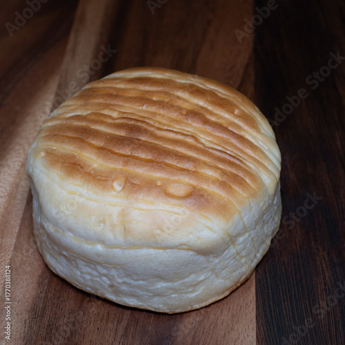 Golden cheese bread with a soft, fluffy texture and melted cheese baked into its crust, creating a warm, savory aroma and rich, delicious flavor.