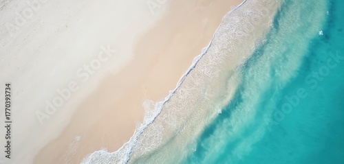 Aerial view of turquoise sea and white sand beach. Waves wash ashore on tropical coast. Paradise scenic seascape view. Summer vacation holiday at sea resort shoreline.