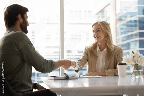 Happy successful blonde business professional woman shaking hands with boss