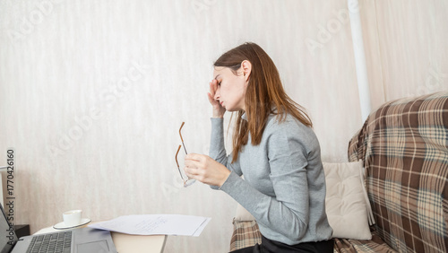 Stressed overworked business woman working from home take off glasses feel eye strain fatigued from laptop computer. Tired freelancer suffer from headache pain, remote work concept