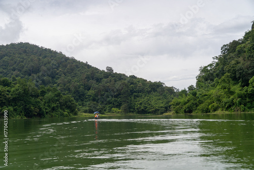 A man is in a blue boat on a lake