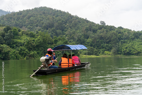 A boat with a blue canopy and a man in a red hat