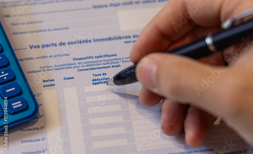 Une personne en train de remplir une case pour la déclaration des revenus des impôts pour l’année 2026 en France.