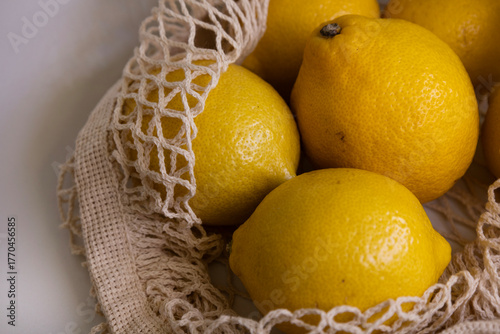 Fresh Lemons in Mesh Bag – Modern Lifestyle Concept on White Minimal Background