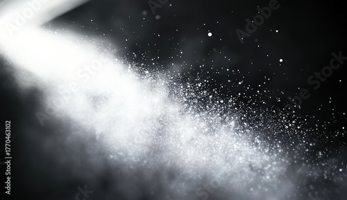 A beam of light illuminates fine particles in a dark environment, creating a captivating and ethereal effect.