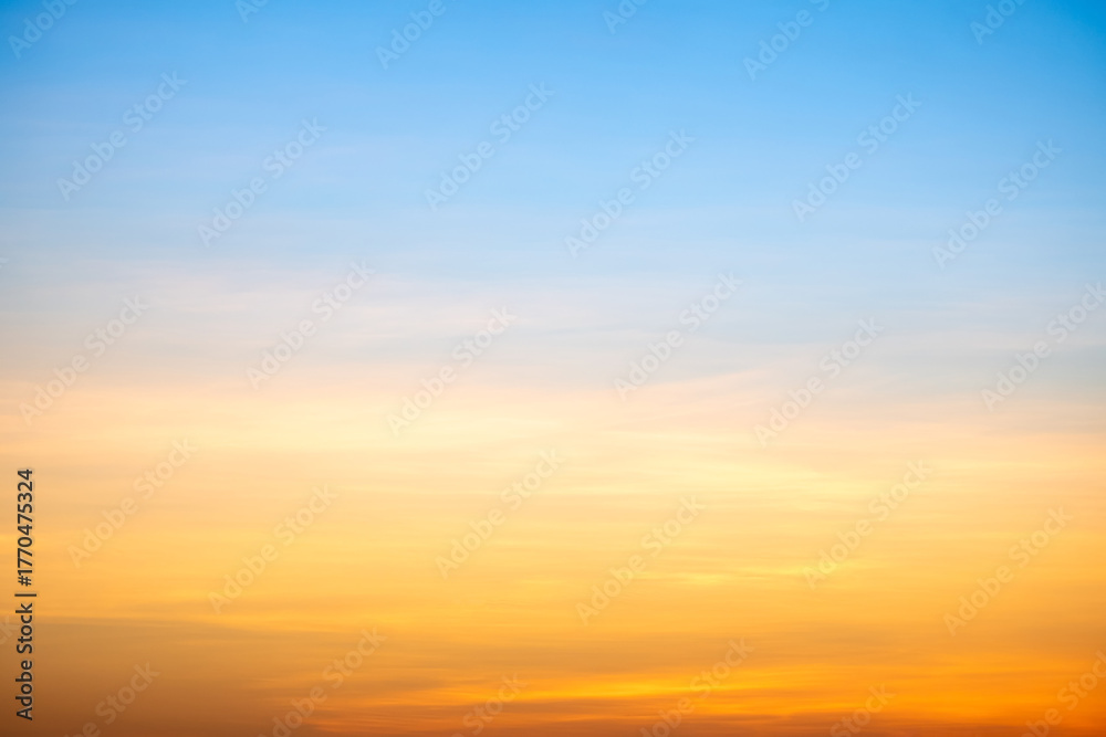 Obraz premium Sunset or sunrise sky with a vibrant gradient of orange, gold, and soft blue. Clear atmosphere with wispy clouds. Peaceful, natural light background. hope, freedom, new day and inspirational Concepts