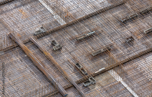 Reinforcing mesh laid on a base for pouring concrete to create a monolithic floor between the floors of a high-rise building