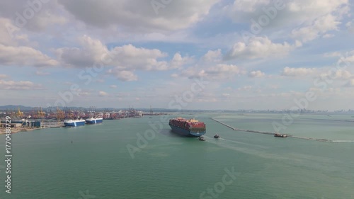 Aerial tracking shot of a large cargo container ship sailing into Laem Chabang Port in Chonburi, Thailand
