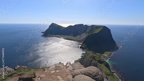 4K travel video showing a person walking toward a rocky edge overlooking a scenic Norwegian island and sea.