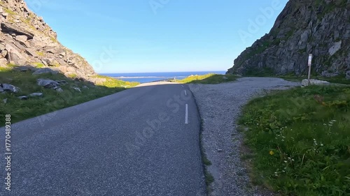 4K travel video showing a car driving along a winding mountain road in Norway with scenic rocky peaks.