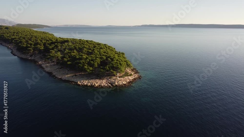 small uninhabited island in the Adriatic Sea, Croatia, shot by a drone, early autumn, late morning, the camera is stationary