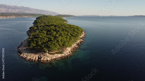 small uninhabited island in the Adriatic Sea, Croatia, shot by a drone, early autumn, late morning, the camera is stationary
