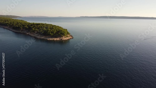 small uninhabited island in the Adriatic Sea, Croatia, shot by a drone, early autumn, late morning, the camera is stationary
