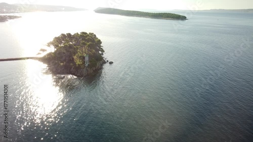 small uninhabited island in the Adriatic Sea, Croatia, shot by a drone, early autumn, late morning, the camera is stationary