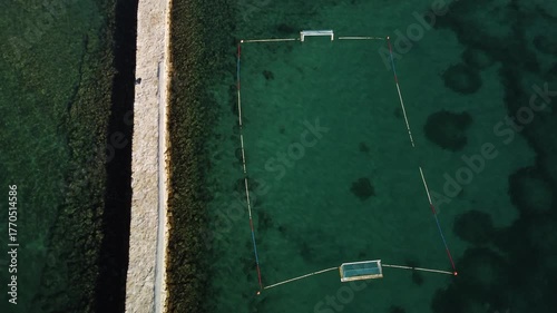 water polo field by the sea, by the concrete jetty, sunny day, summer, calm sea, view from a drone