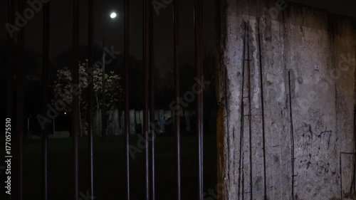 Wall path, Berlin Wall Memorial Center, Berlin Wall Landmark. Berlin Wall Memorial is softly lit by dim streetlights, creating serene nighttime view path and surroundings.