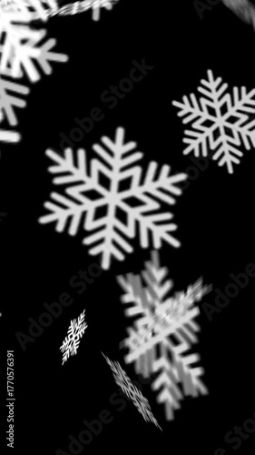 Vertical Animated falling snowflakes on a black background. A simple winter animation representing Christmas, cold season, or festive atmosphere with soft, rotating snowflake motion. Alfa channel.