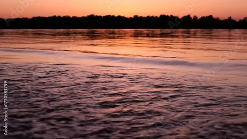 Sunset over water with gentle waves.